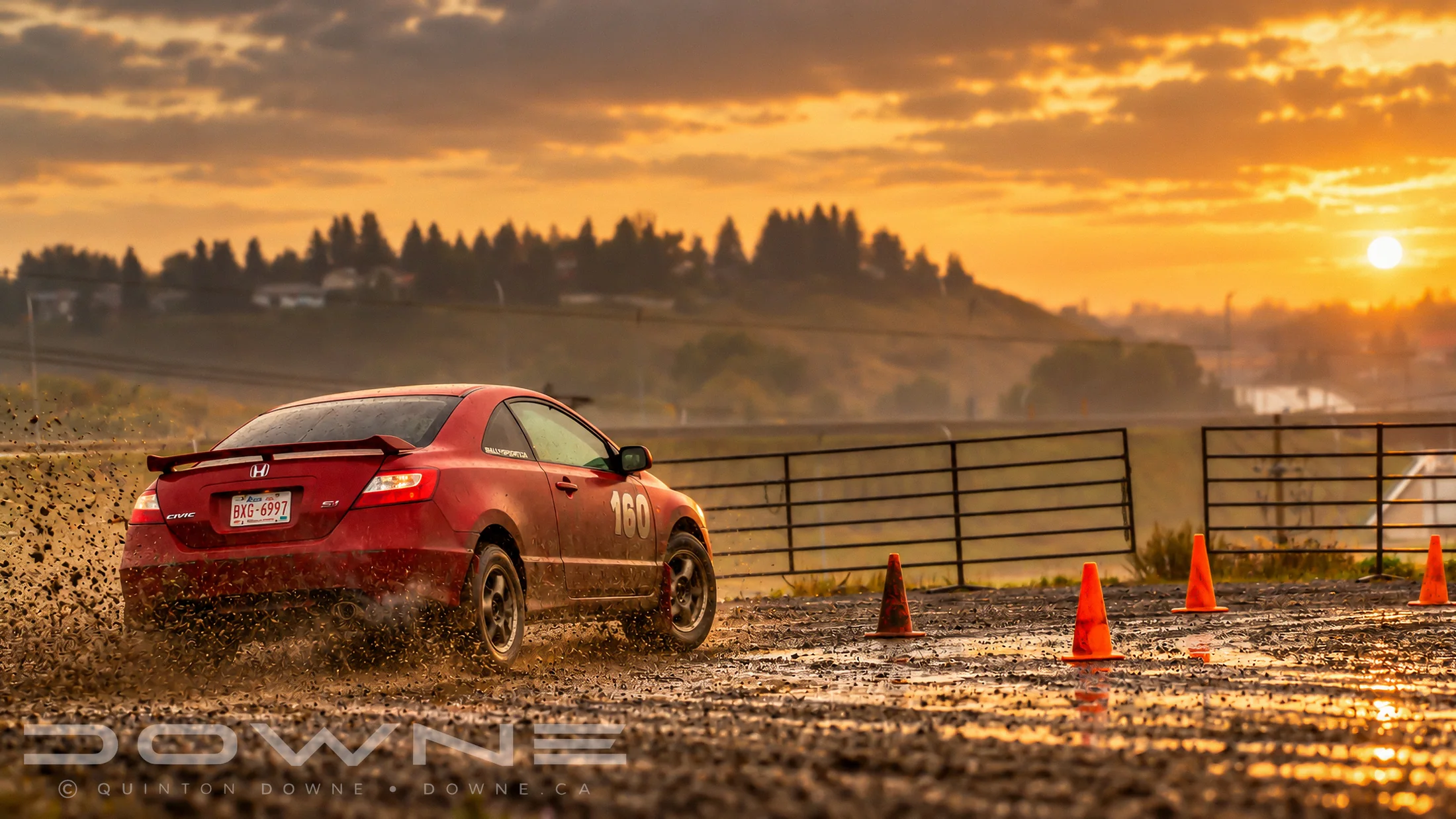 Rallycross car crossing a dusty course at sunset — photograph by QDowne